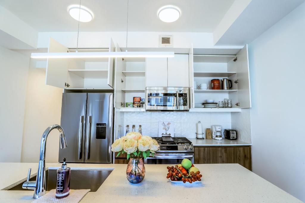 卡尔加里Vibrant & Modern Loft-style Walkout Near LRT的厨房配有不锈钢冰箱和水槽