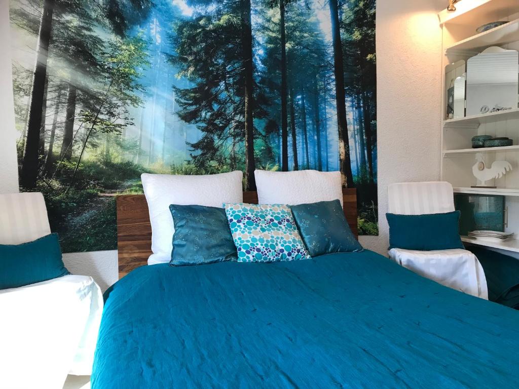 塞埃巴克Vogelhäuschen的卧室配有一张蓝色的床,墙上挂着一幅画