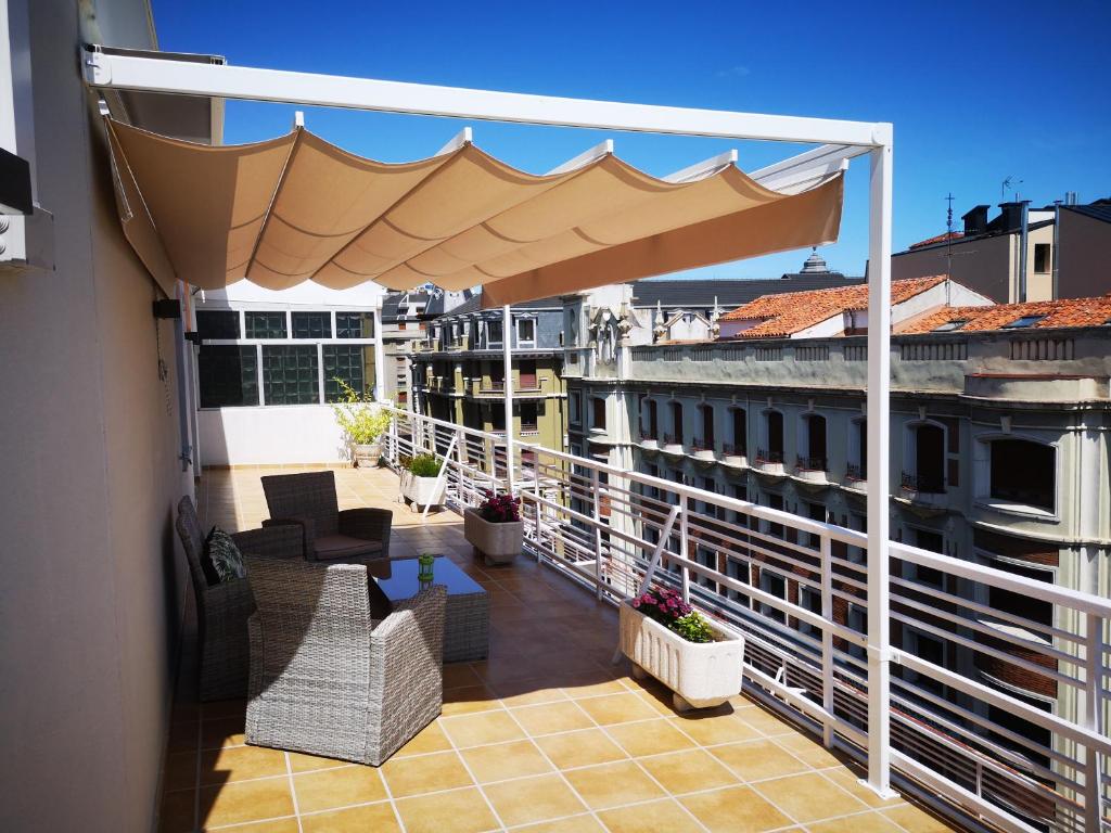 莱昂BURGO NUEVO Ático de lujo en pleno centro con terraza y vistas - leonapartamentos的大楼内带大伞的阳台