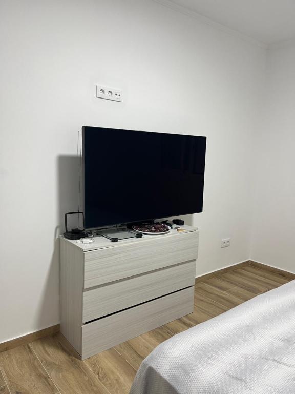 巴塞罗那Apartamentos La Meridian的卧室的梳妆台上配有平面电视