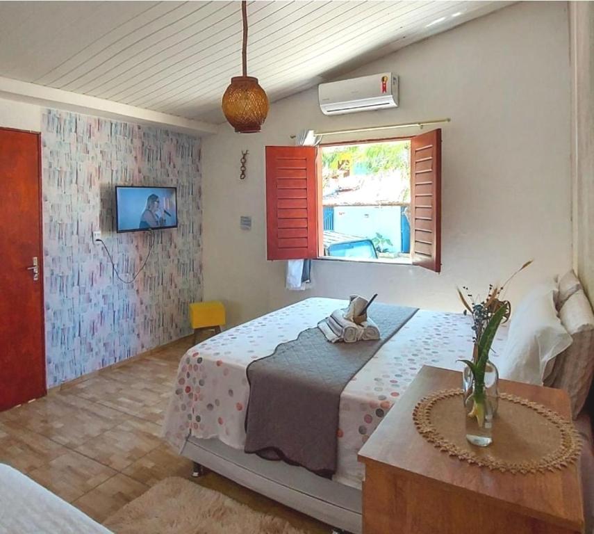 杰里科科拉Na Casa Delas Jericoacoara的一间卧室设有一张床、一个窗口和一张桌子