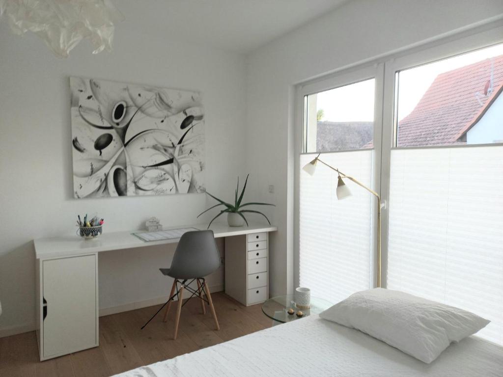 埃夫林根基兴Privates Zimmer mit Bad的一间卧室配有一张床、一张书桌和一个窗户。