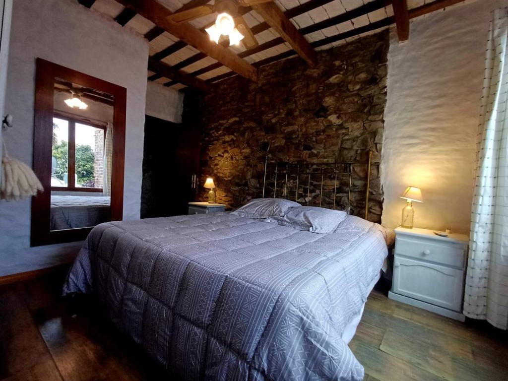 科洛尼亚-德尔萨克拉门托Posada San Gabriel的一间卧室设有一张床和石墙