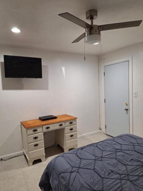 红木城Garden motel的一间卧室配有一张桌子和一台墙上的电视。