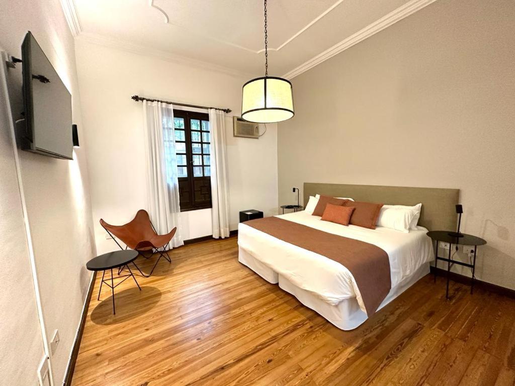 萨尔塔总督酒店的一间卧室配有一张床和一台电视