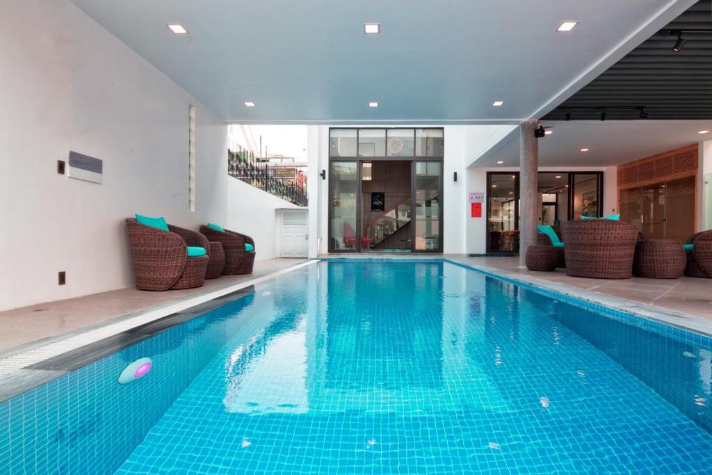 岘港Luxury Beach Villa Da Nang的大楼内带椅子的大型游泳池