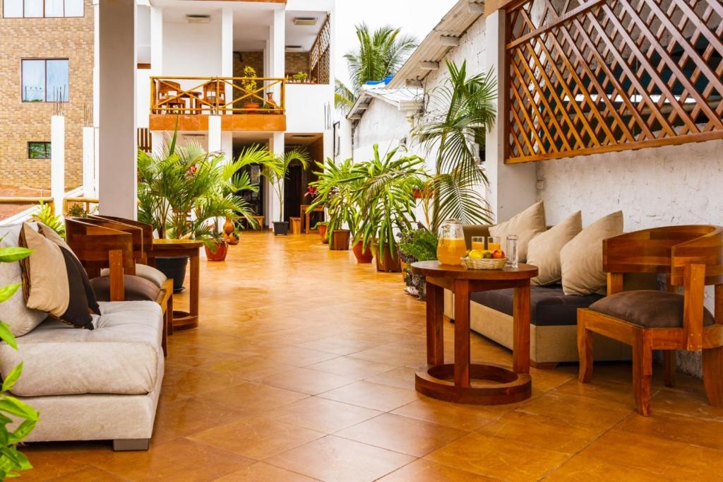 阿约拉港EXCLUSIVE CONDO GALAPAGOS & BEYOND 2的大堂配有沙发、桌子和植物