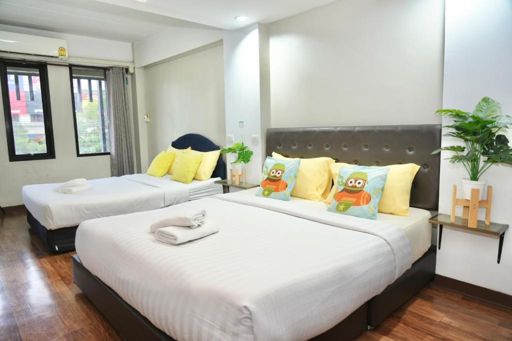 Ban Khlong PrawetBkk39 Airport hotel的一间卧室配有两张带黄色枕头的床