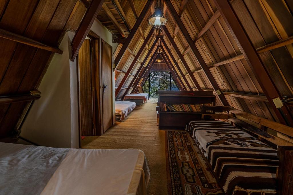 El TigreChalet Lander Colonia Tovar的木制天花板的客房内设有几张床。