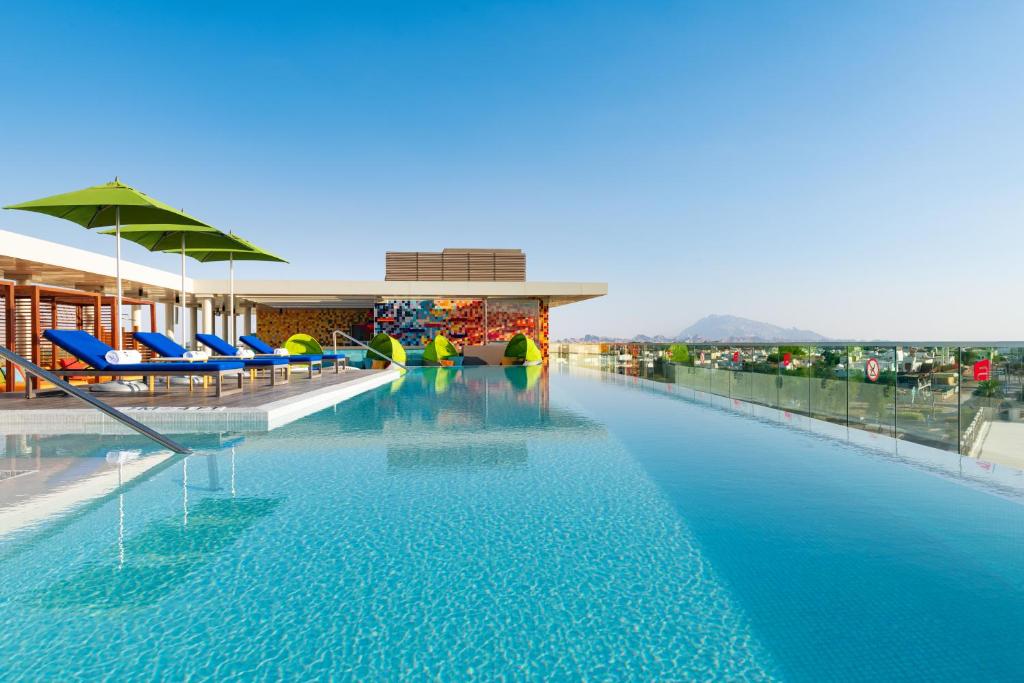艾恩艾恩雅乐轩酒店的一座带蓝色椅子的游泳池和一座建筑