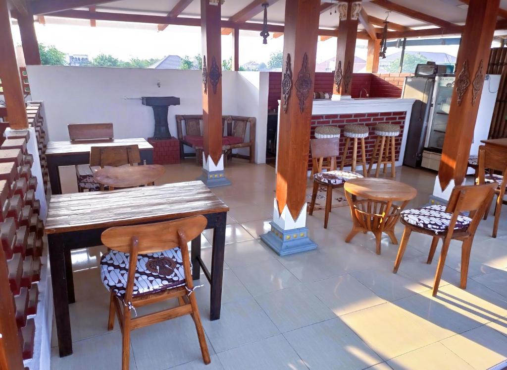 日惹ZEN MOON Hostel的一间带木桌椅的餐厅和一间酒吧