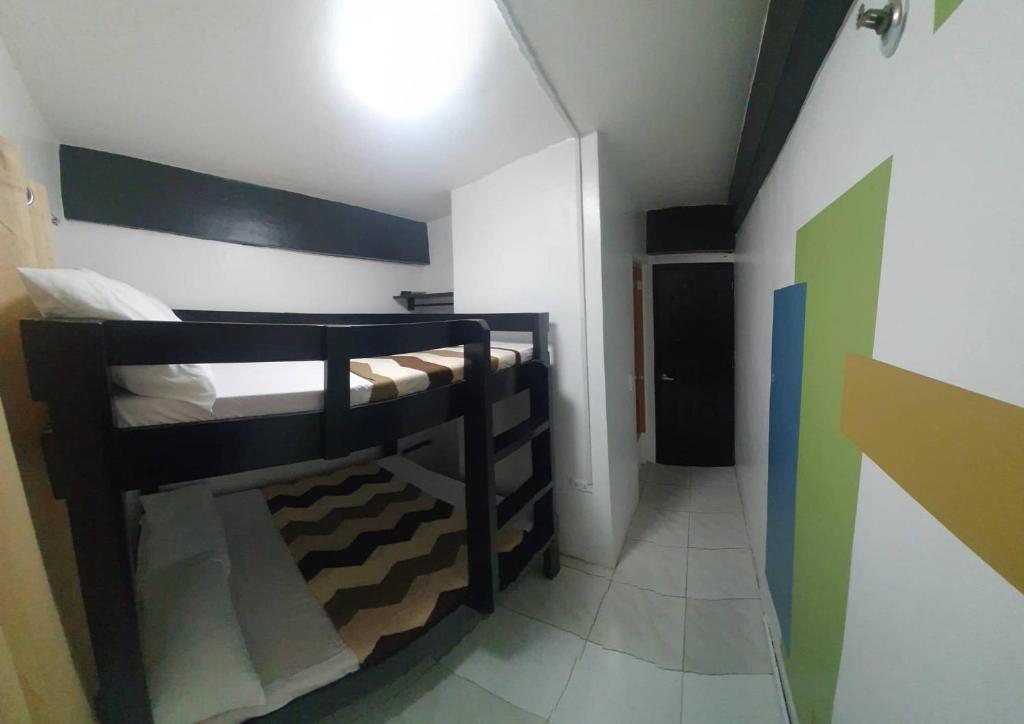 长滩岛Villa Tomasa Boracay Dmall的小房间设有两张双层床和走廊