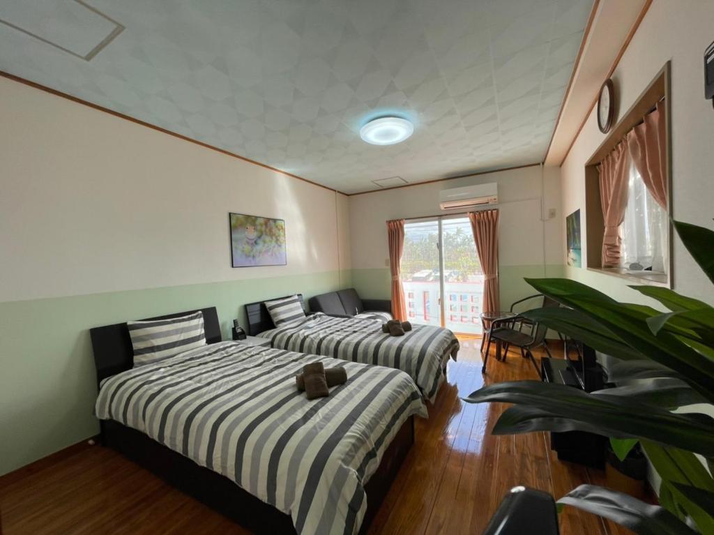 名户NAGO Sakura Resort Inn - Vacation STAY 14448v的绿墙客房内的两张床