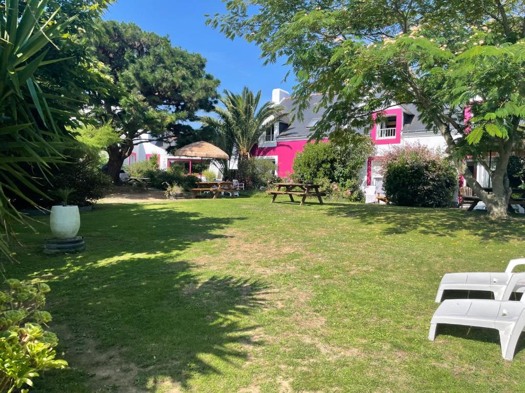 索宗奥克斯塔瑞酒店的一座带两个白色长椅的院子,一座粉红色的房子