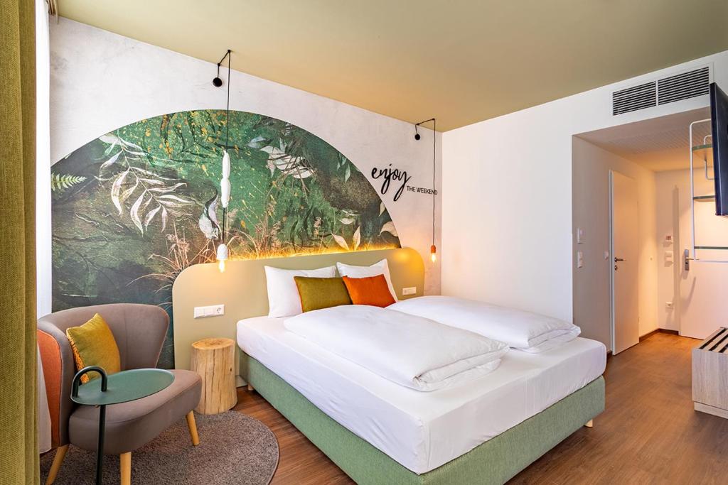 维也纳The Weekend Hotel的卧室配有一张大床,墙上挂有绘画作品