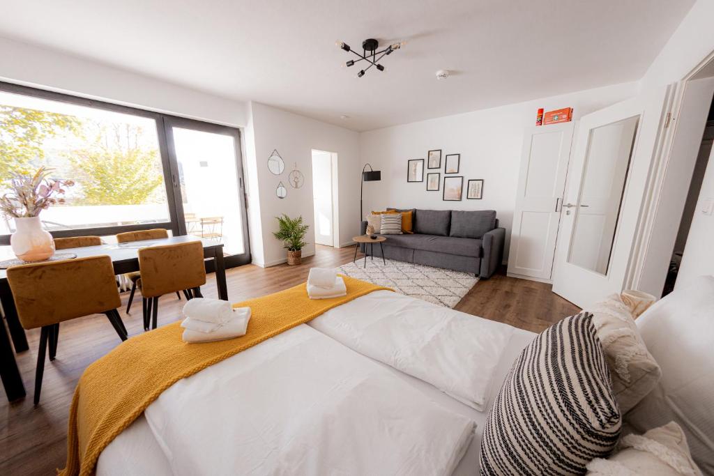 帕绍Come4Stay Passau - Apartment Seidenhof I voll ausgestattete Küche I Balkon I Badezimmer的一间带大床的卧室和一间餐厅