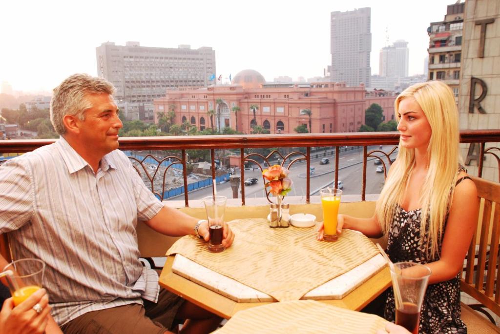 开罗City View Museum Hotel的坐在阳台上桌子上的男人和女人