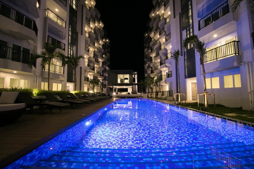 Ban Tha FatMantra Beach Condominium Suite - Mae Phim的大楼内带蓝色灯光的游泳池