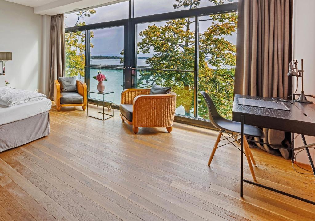 腓特烈港艾卡海滨生活酒店的一间带一张床和一张书桌的卧室以及一间带窗户的卧室。
