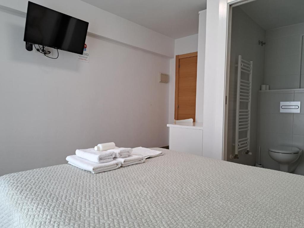 桑图尔特西Pension Iruna的白色卧室,配有带毛巾的床