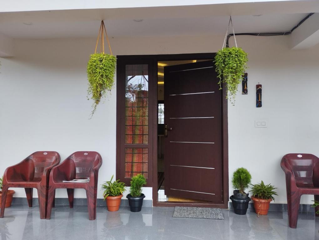 瓦加蒙SHI's Vagamon Hill Retreat- Private villa on Hills的一个带椅子的房间和一扇植物门