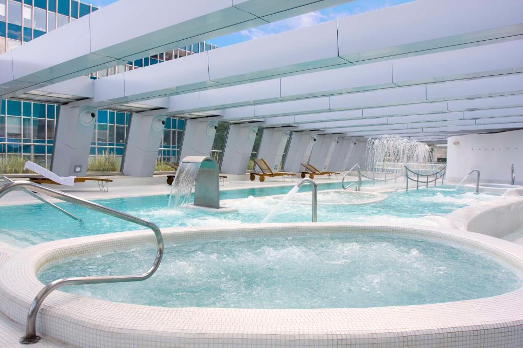 马德里马德里欧式建筑NH精选酒店的一个带热水浴缸的大型游泳池