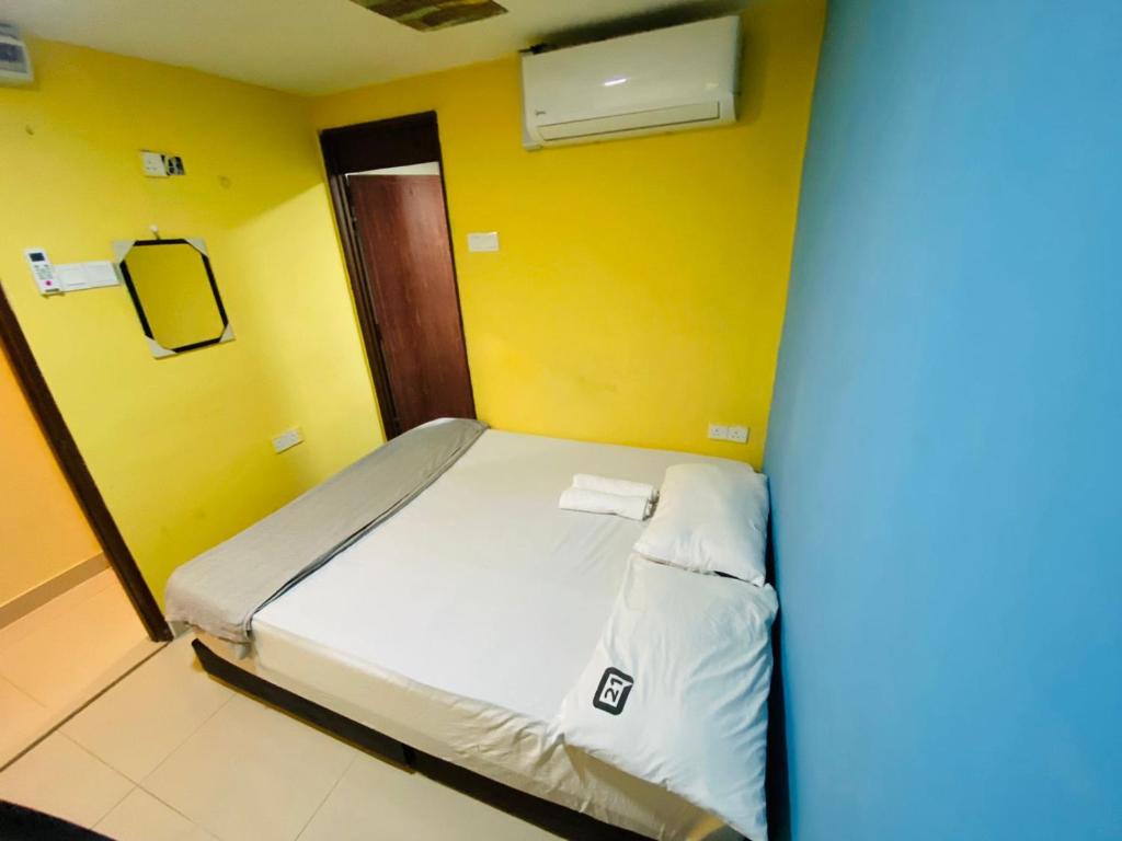 吉隆坡RAS International Hotel的黄色墙的房间里一张床位