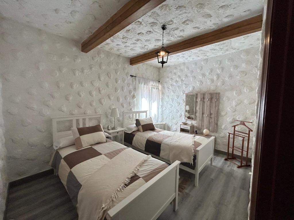 圣克鲁斯-德特内里费Casa Rural Juli的卧室设有2张床和白色的墙壁。