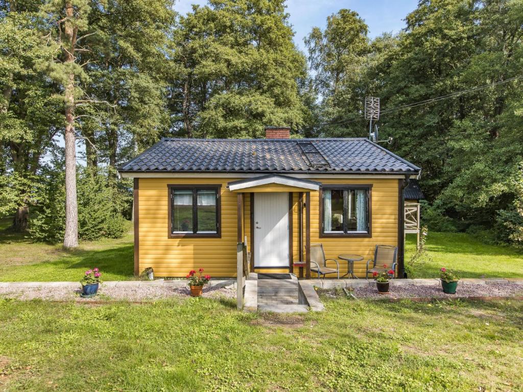 FjälkingeHoliday Home Kjuge Gula Huset by Interhome的田野上一个小黄小房子