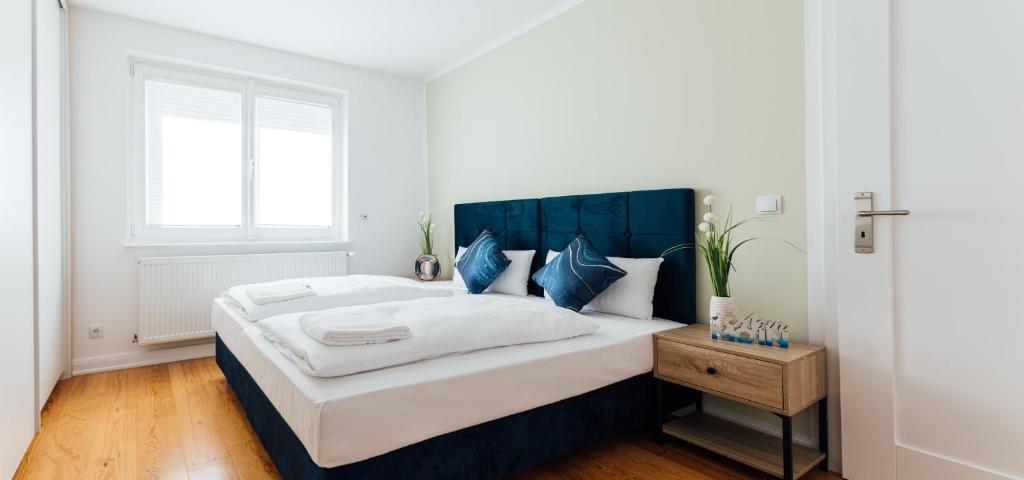 汉堡Hanseat Apartments的一间卧室配有一张大床和蓝色床头板
