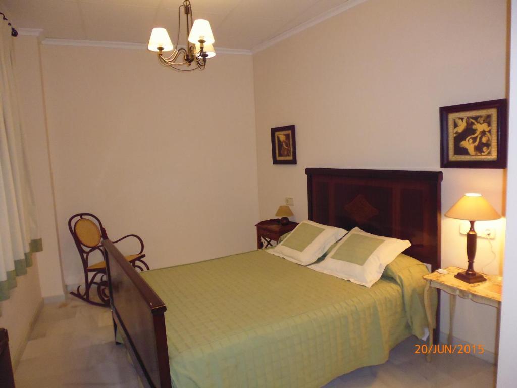 AlboreaHostal Artiga的一间卧室配有绿色的床和一盏灯