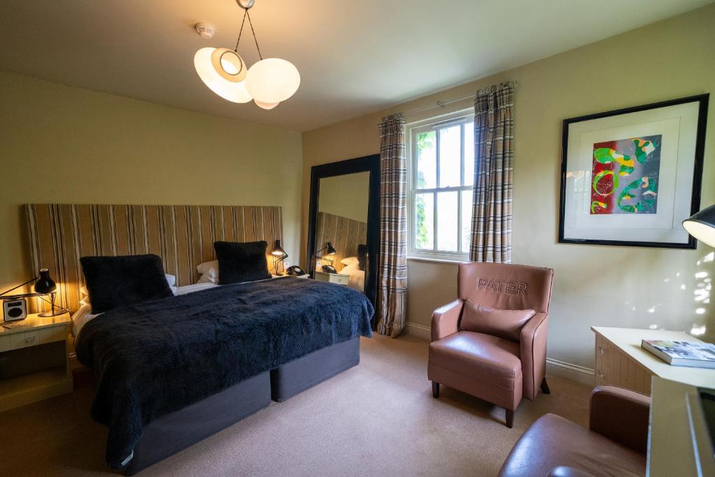 戴德姆密斯欧米斯酒店的一间卧室配有一张床和一把椅子