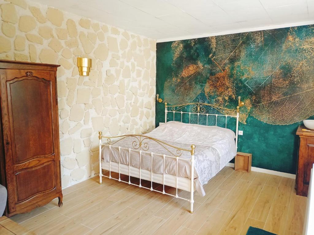 SacyBulles de Lune的卧室配有一张床,墙上挂有绘画作品