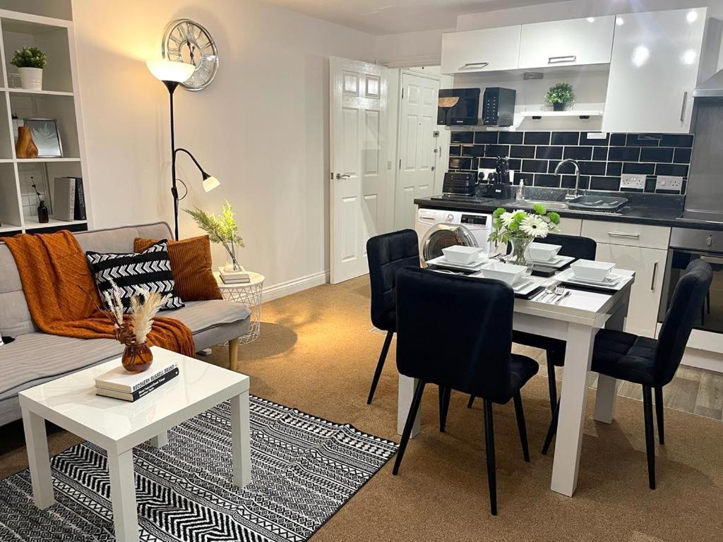布里斯托Stockwood Apartment by Cliftonvalley Apartments的厨房以及带桌子和沙发的客厅。