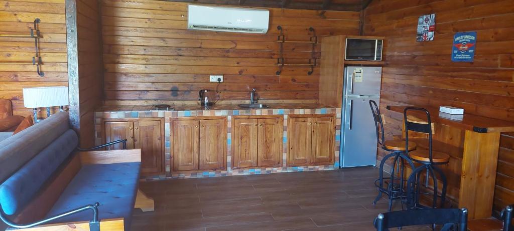 利雅德Antola Resort Al Rimal的厨房配有木制橱柜、冰箱和水槽。