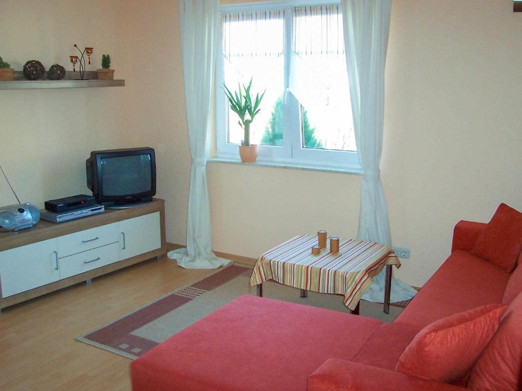 维斯马Ferienwohnung im Ostseeblick的客厅配有红色沙发和电视