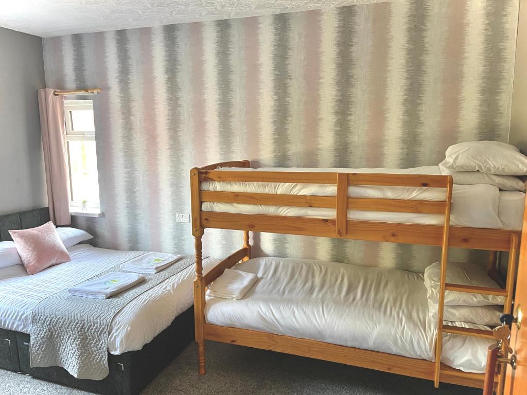 斯凯格内斯The Cresswell Inn的一间卧室设有两张双层床和一扇窗户。