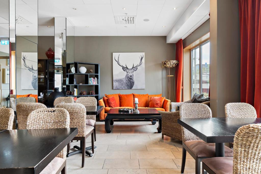 索尔纳Best Western Solna Business Park的客厅配有橙色沙发和椅子