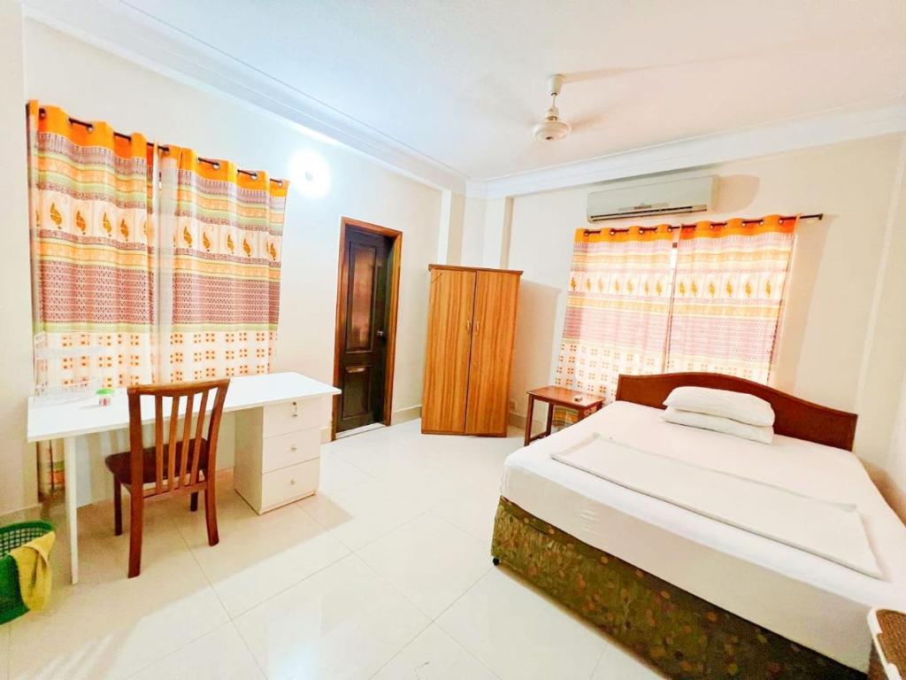 达卡Maya Eco Apartment Service的一间卧室配有一张床和一张书桌