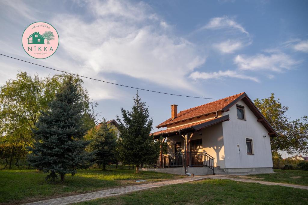 MandičevacNikka Resthouse Mandićevac的前面有一棵树的白色房子