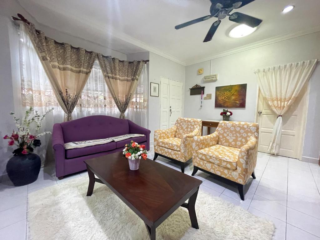 卢穆特Venice Raudhah Guest House的客厅配有紫色沙发和桌子