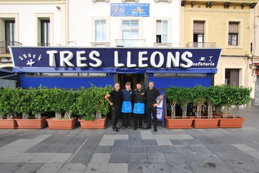 滨海比拉萨尔Hotel Tres Leones的一群站在树衣店前的人