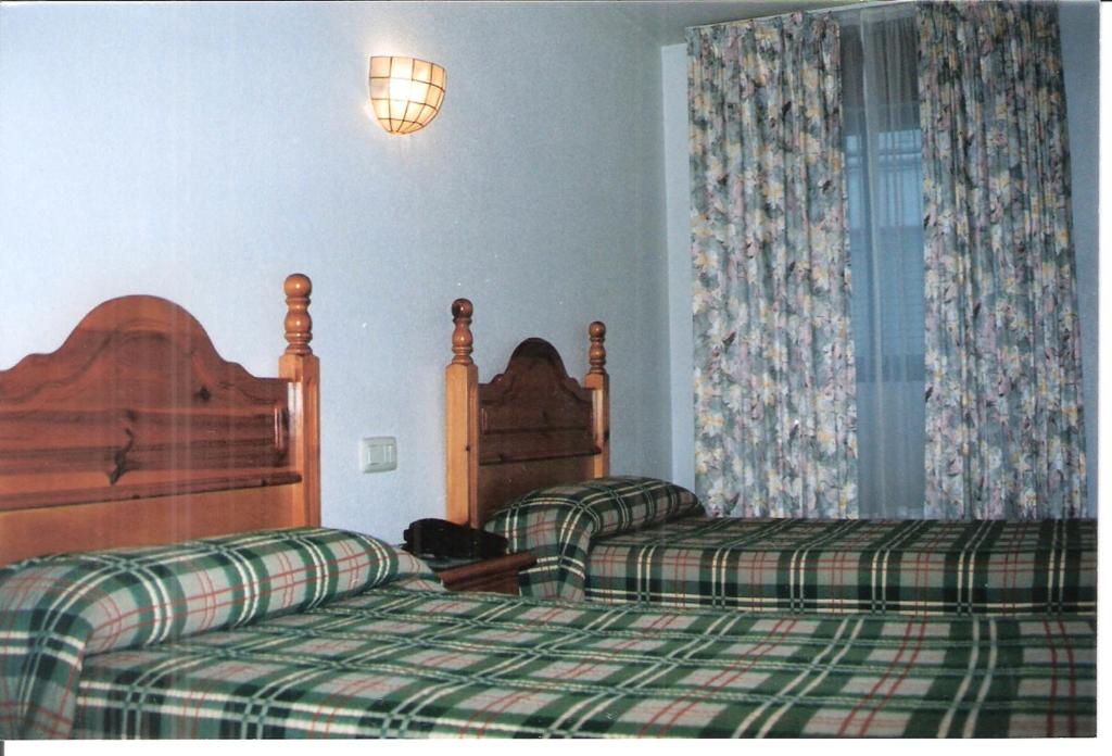 巴达霍斯Hostal Niza的酒店客房,设有两张床和一盏灯
