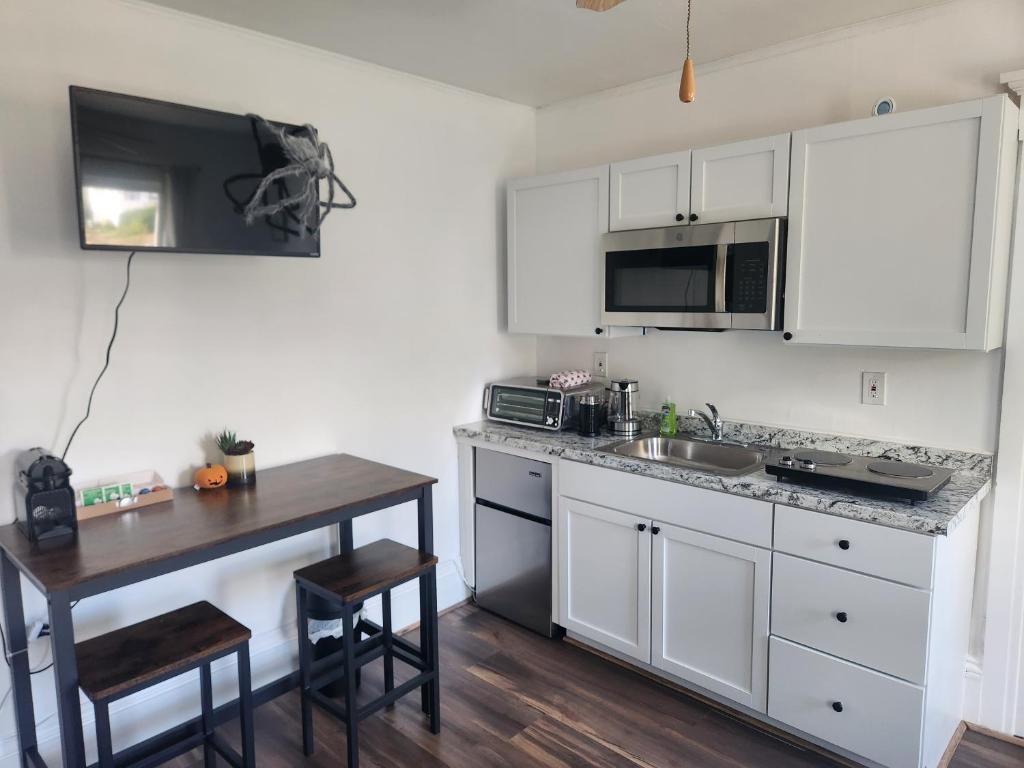 曼切斯特Street side studio apartment的厨房配有白色橱柜和木桌