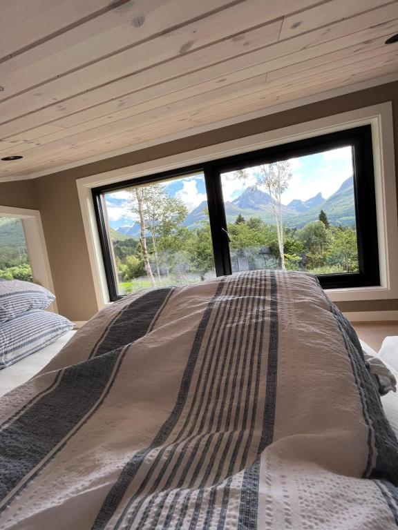 IsfjordenKavliskogen panorama的一张位于带大窗户的房间内的床铺