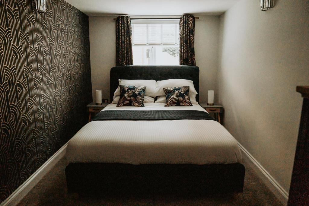 HoltRetreat on the Green的卧室配有带枕头的床铺和窗户。