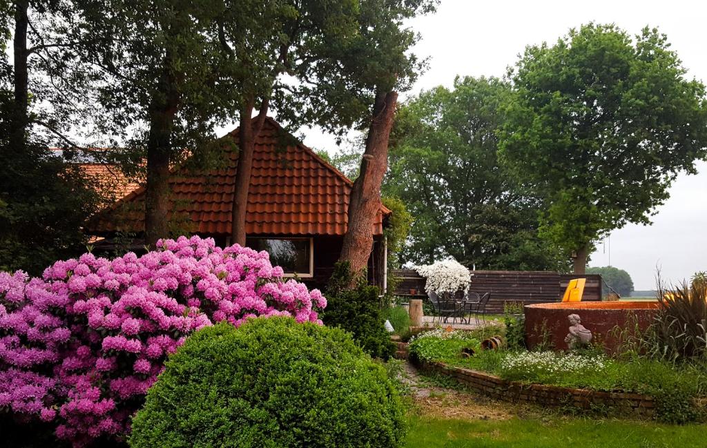 Villa Artem的一座花园,在房子前方种有粉红色的花朵