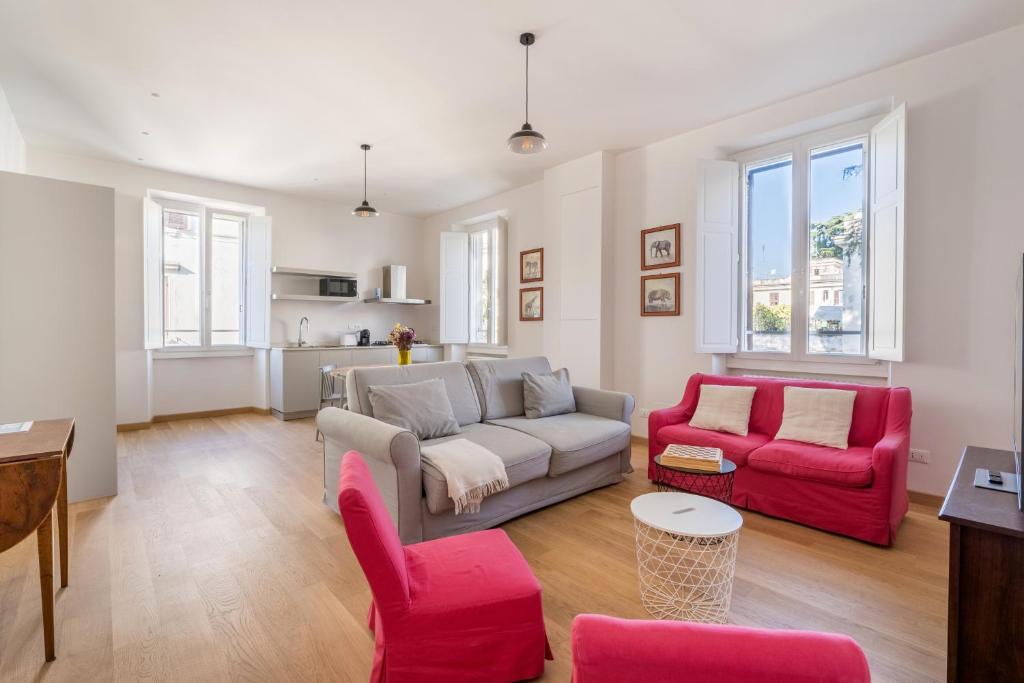罗马Fisher's Apartment in Testaccio的客厅配有沙发和2把红色椅子