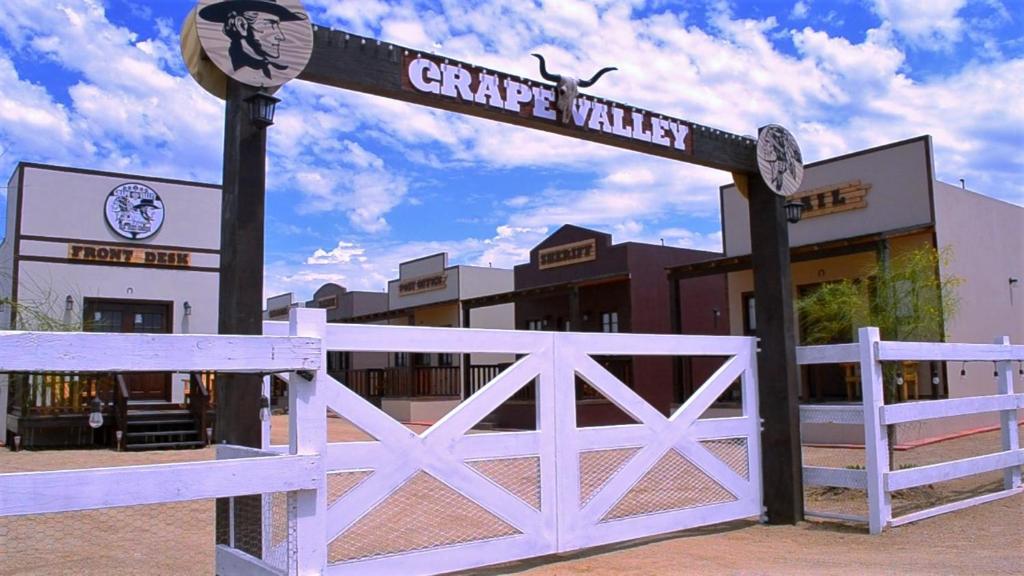 恩塞纳达港Grape Valley Old West Cabins的建筑前的白色栅栏标志