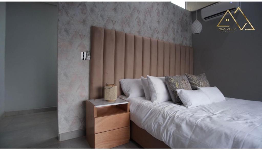 索赫燕杜Villa 698 tswinga的一间卧室配有一张大床和木制床头板